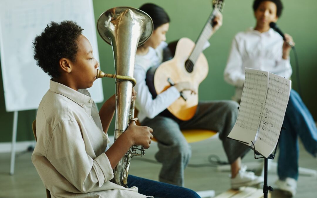 A children's music band performing, each child playing a different instrument
